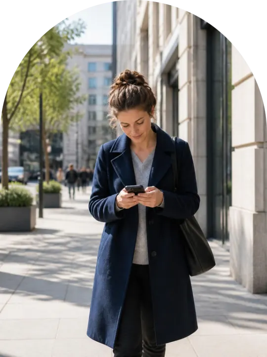 A woman in a city street looking at her phone